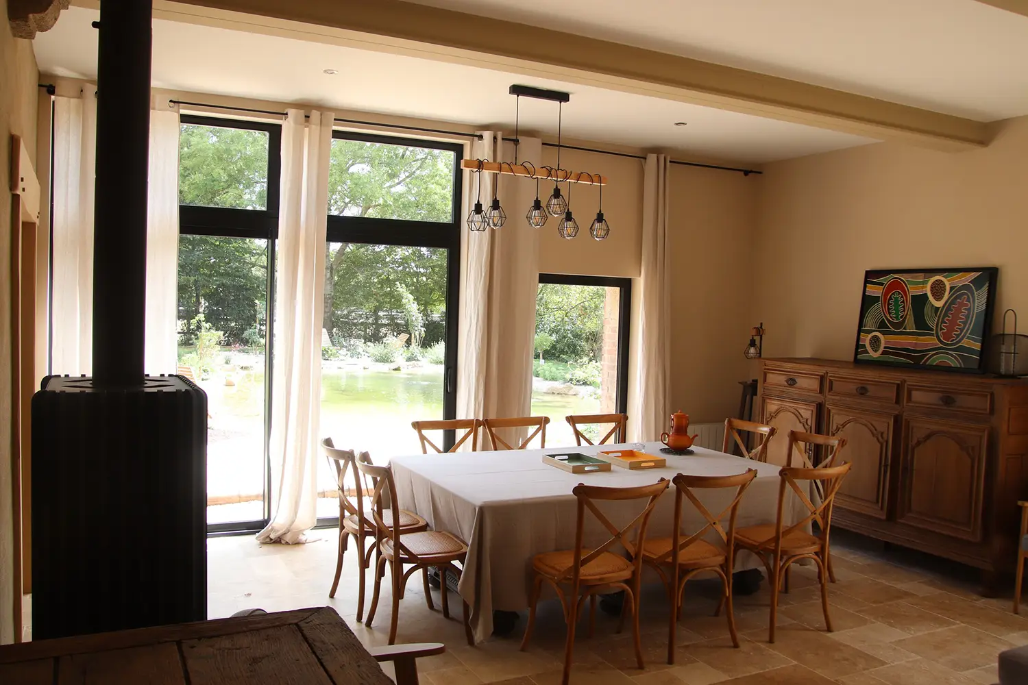 Salle à manger lumineuse avec vue sur le jardin et le bassin
